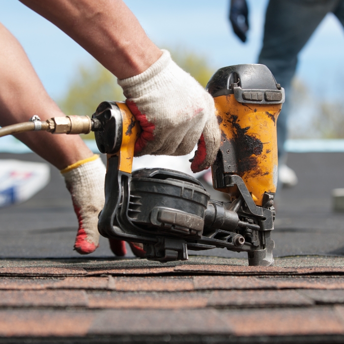 contractor hand with nailgun close up repairing asphalt shingles roof salisbury nc